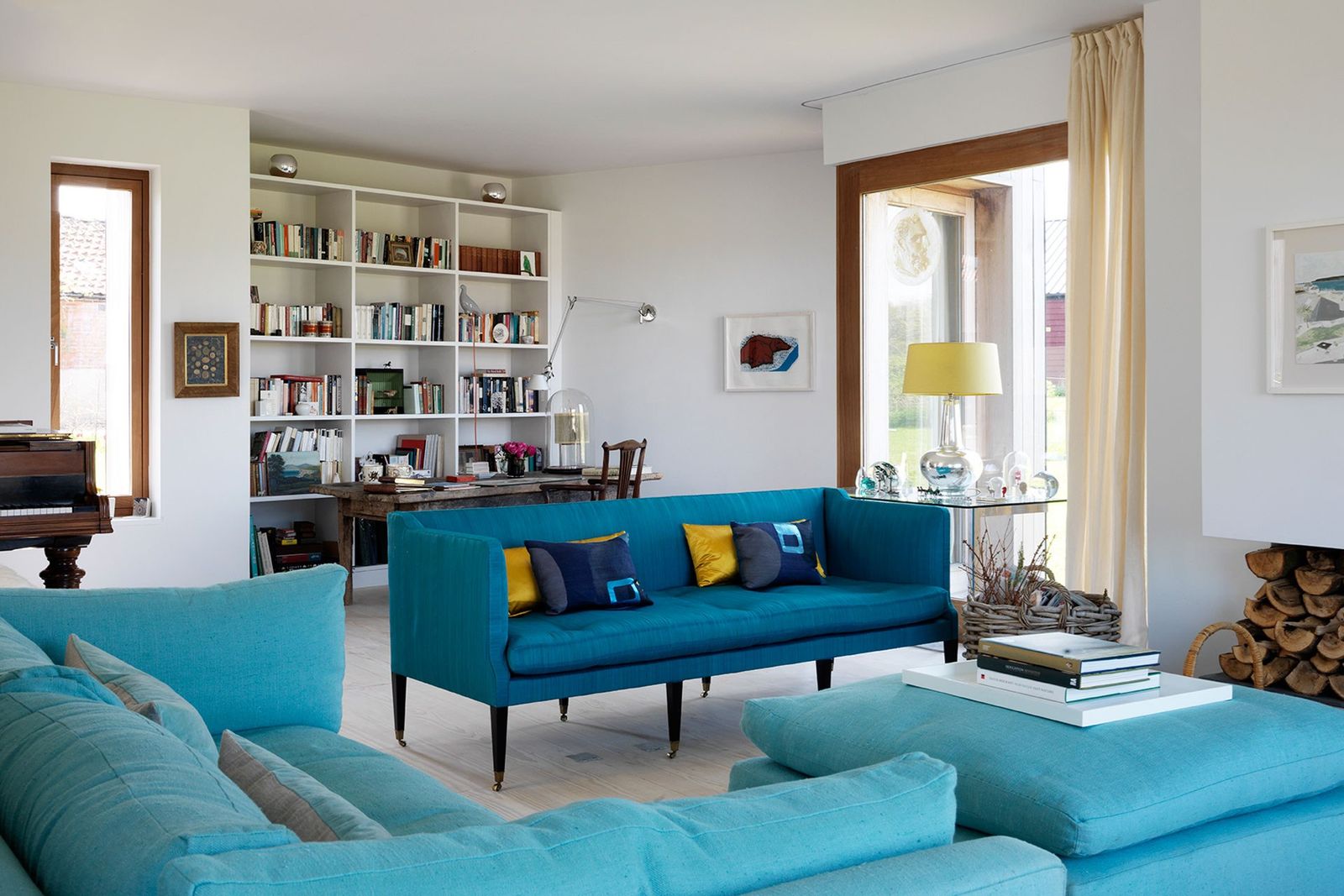 Image may contain Living Room Room Indoors Furniture Couch Interior Design Shelf Cushion Rug and Bookcase