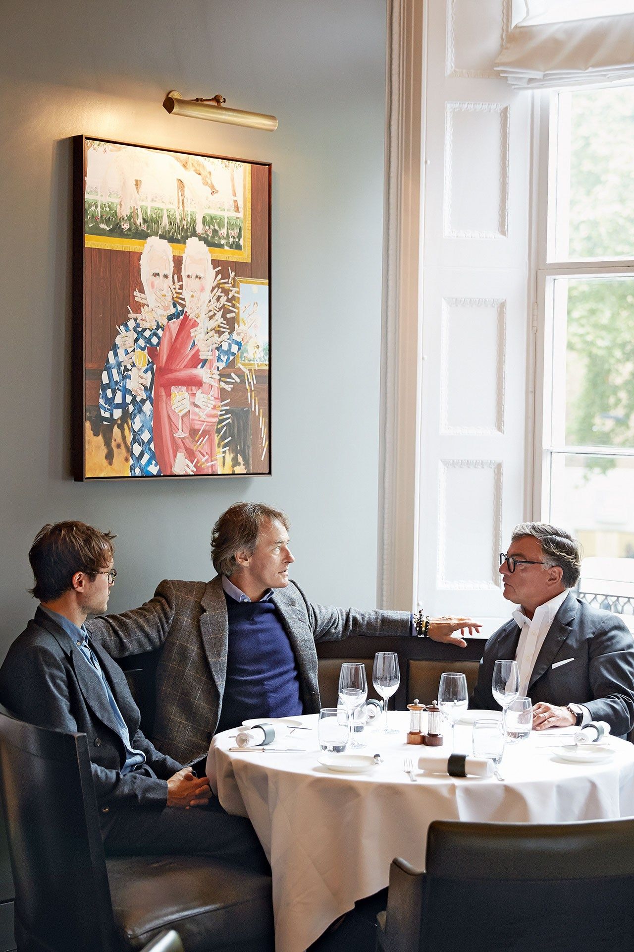 Image may contain Furniture Chair Sitting Human Person Restaurant Suit Coat Clothing Overcoat and Apparel