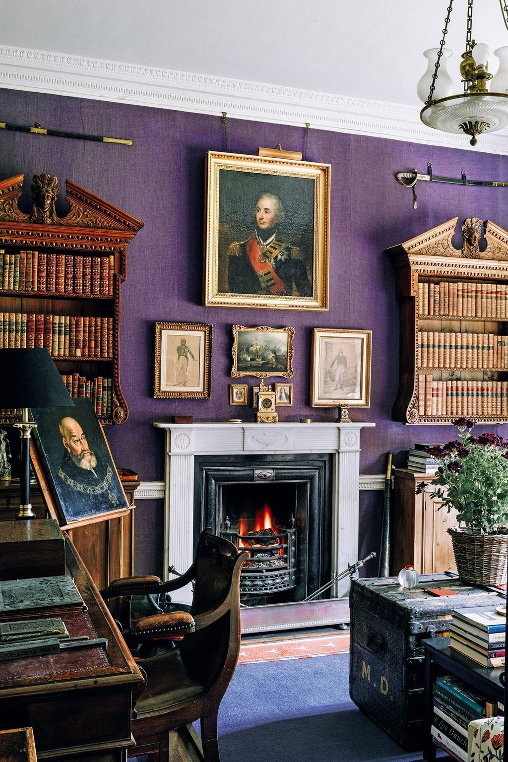 Image may contain Indoors Fireplace Interior Design Furniture Human Person Chair Hearth and Bookcase