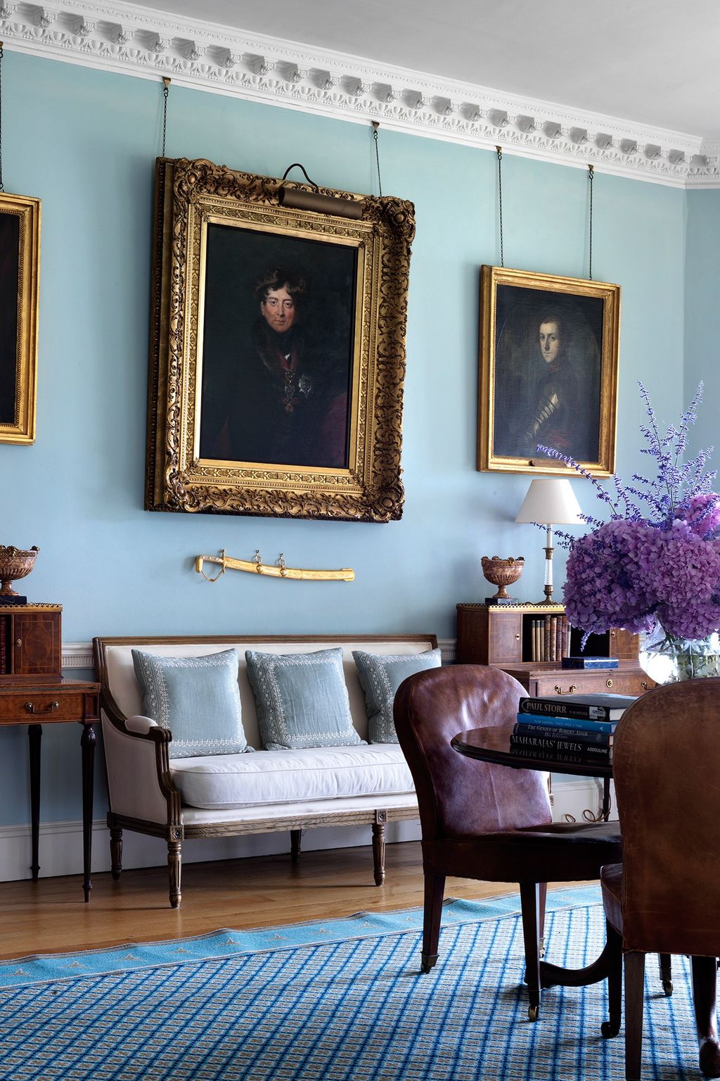 Image may contain Furniture Living Room Room Indoors Chair Flooring Human Person Wood Rug and Hardwood