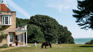 Image may contain Grass Plant Human Person Animal Mammal Horse Outdoors Nature Field Grassland Lawn and Spire