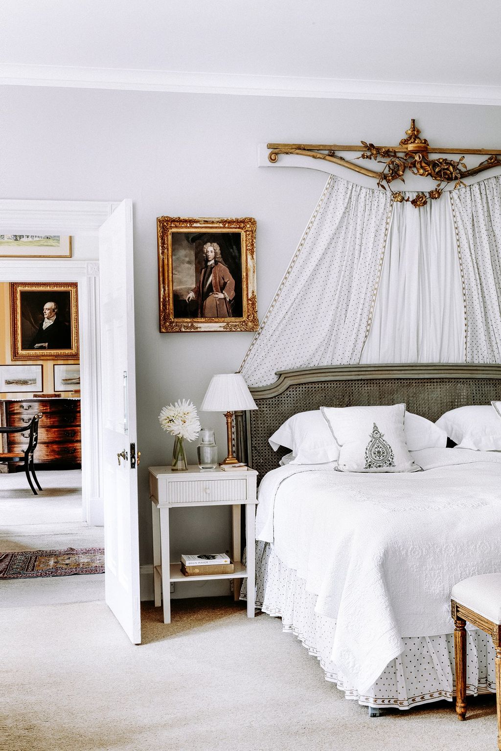 A blockprinted white and gold muslin hangs behind the bed in this room.
