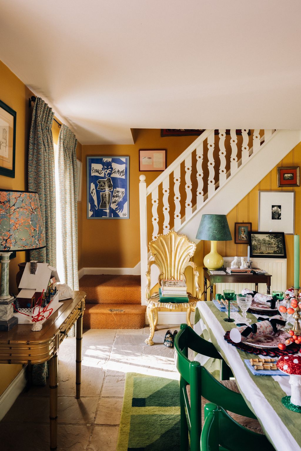 The staircase leads to the first floor. The gold chair is a 19th century Venetian grotto chair sourced from Twig while...