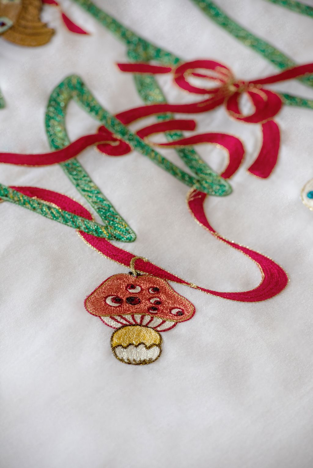 The embroidered bedspread and tablecloth is covered in intricate bauble details.