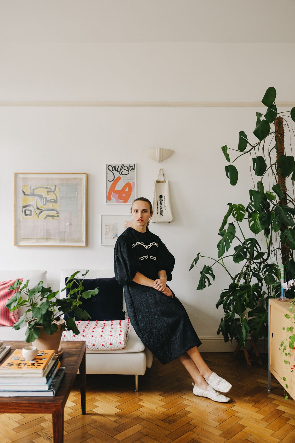 Alfred in his living room wearing a dress from Simone Rocha. The quilt on the sofa is a family piece which Alfred's...