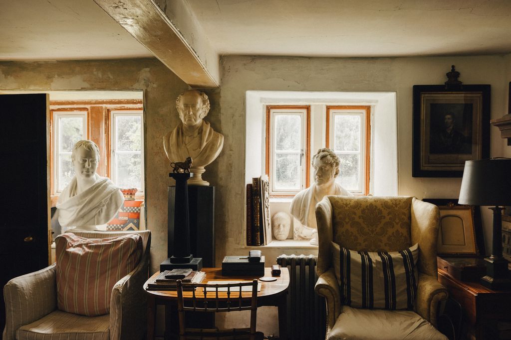 On the left a bust of Sir Walter Scott sits in the window of the parlour the other busts are of unknown subjects. On the...