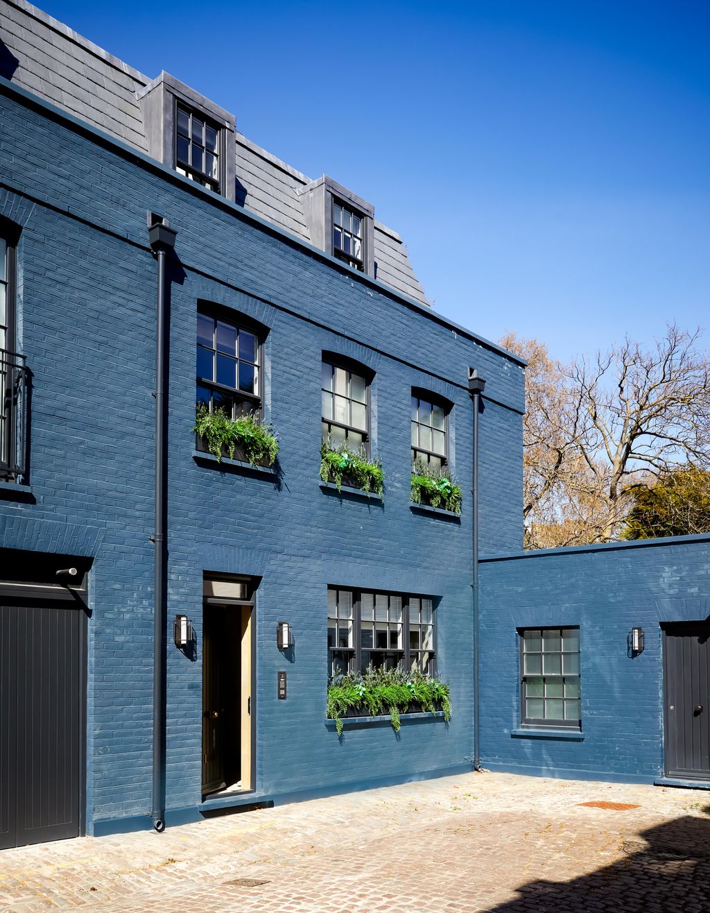 This Studio Caballero mews house has been painted in a striking hue. For this they chose ‘Hague Blue by Farrow  Ball.
