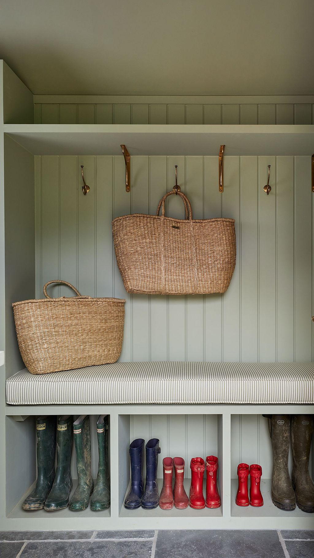 This cosy sage green boot room in the New Forest was designed by Blank Slate perfect for preparing for long country...