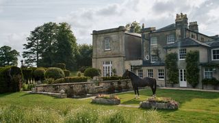 Image may contain Grass Plant Animal Mammal Horse Lawn Housing and Building