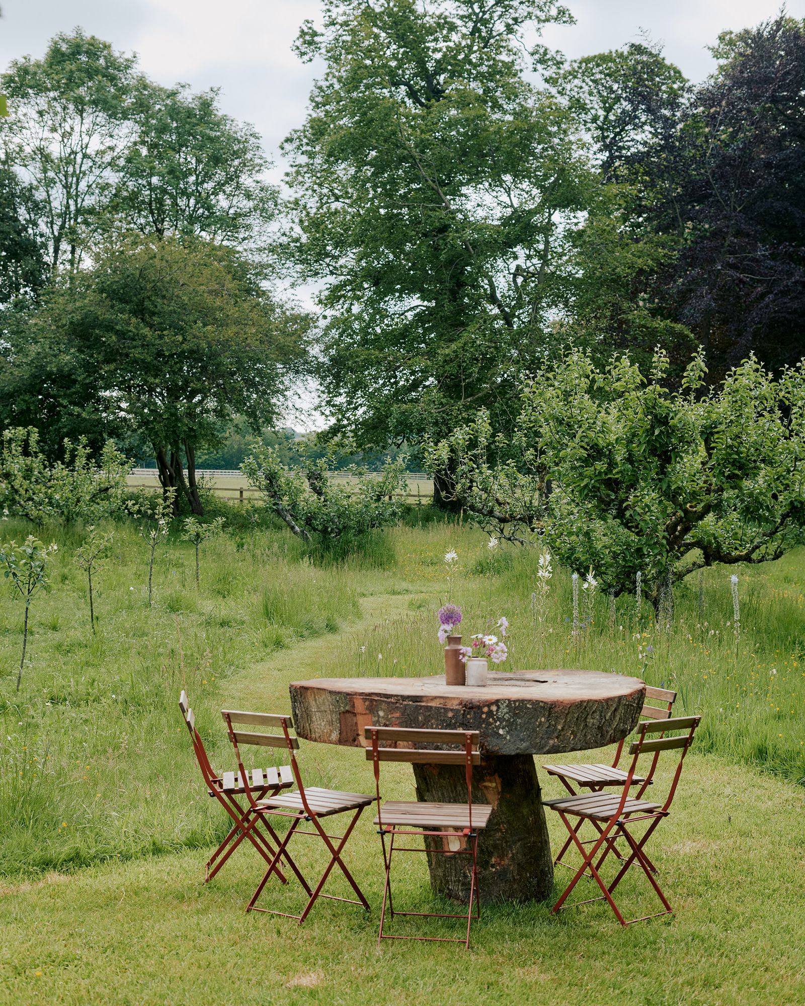 Image may contain Furniture Chair Dining Table Table Grass Plant Water and Outdoors