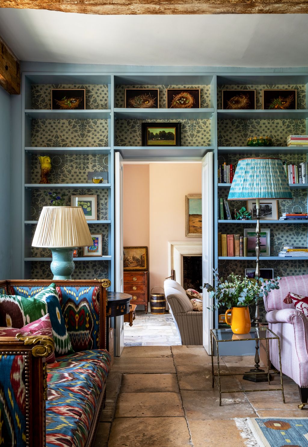 Image may contain Furniture Living Room Room Indoors Shelf Lamp Table Lamp Interior Design and Bookcase