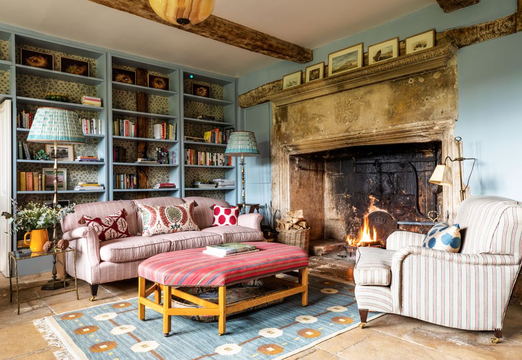 Image may contain Furniture Living Room Room Indoors Couch Rug Table Fireplace Hearth Interior Design and Shelf