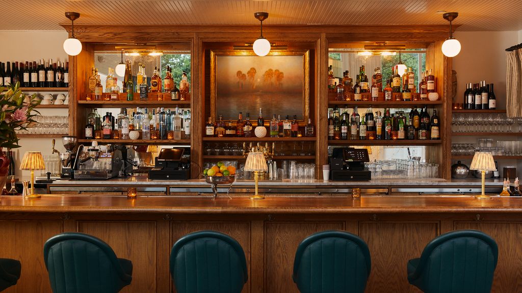 a wooden bar with globe lights and liquor bottles