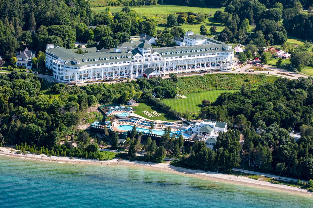 an aerial view of a white hotel on a lake