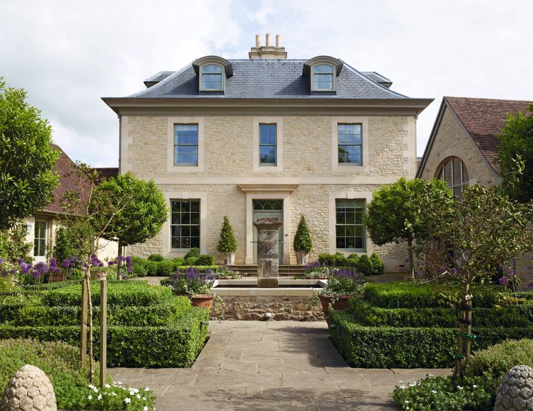 Image may contain: Outdoors, Housing, Building, Garden, Plant, Arbour, Grass, Human, Person, Furniture, Bench, and House