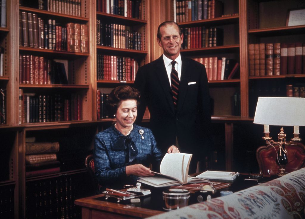 Image may contain Tie Accessories Accessory Philip Tomalin Human Person Furniture Elizabeth II Indoors and Bookcase