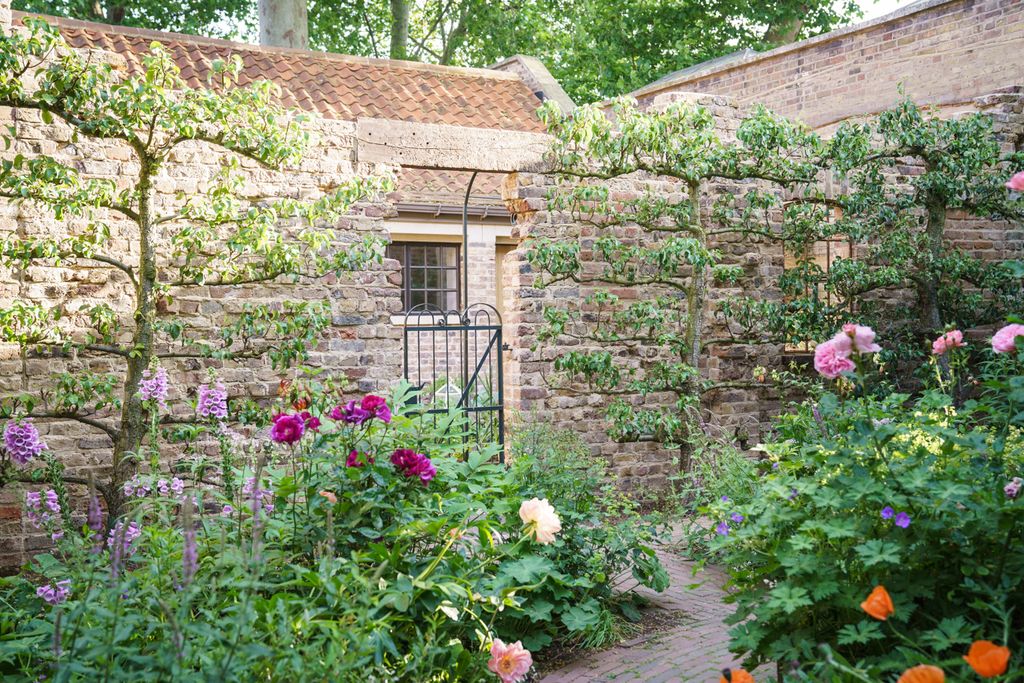 Image may contain Garden Outdoors Arbour Plant Cottage Housing House Building and Brick