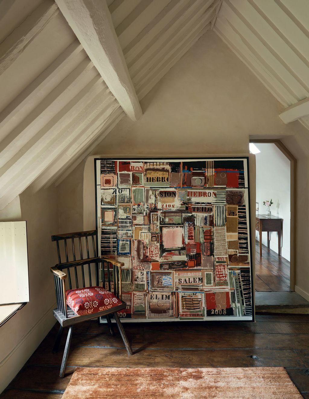 The colours in a painting by John Uzzell Edwards are picked up by the Melin Tregwynt cushion on an antique Welsh stick...