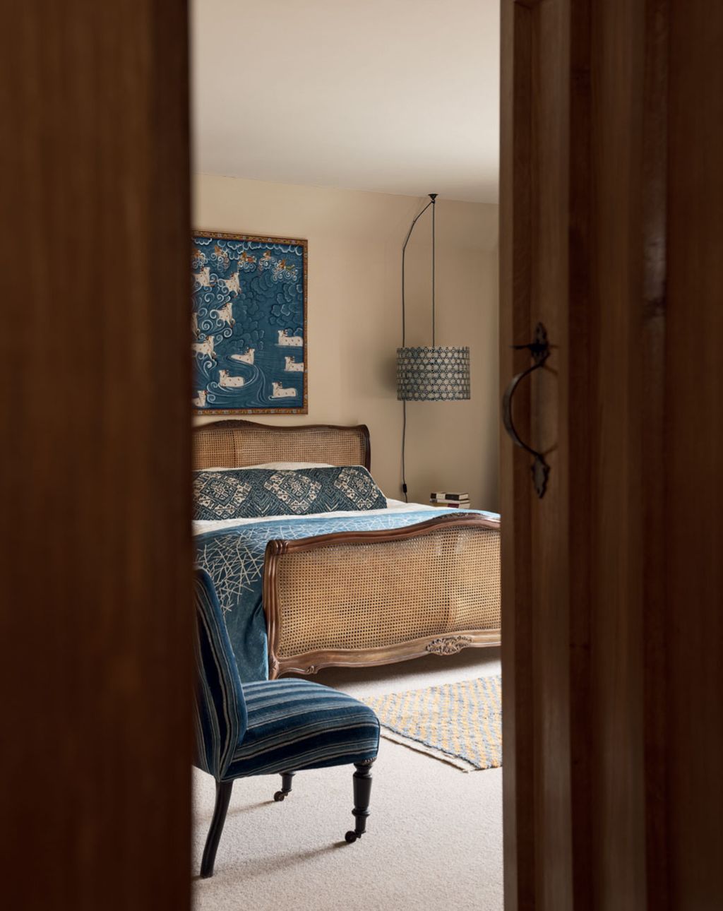 Vintage textiles pick up on the colour of an antique Indian painting above the bed.  buttongroup  Discover more of this...
