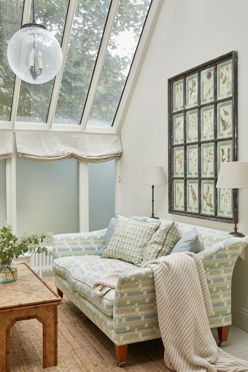 Behind the sofa hangs a set of botanical prints framed in an antique window sourced at Lorfords.