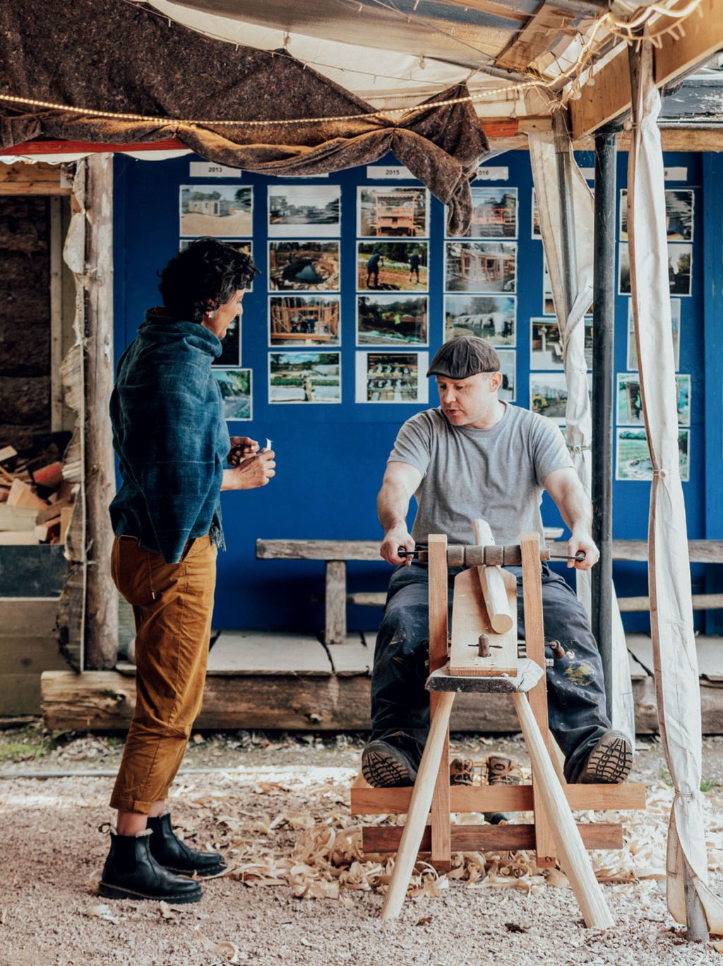 In the workshop at local charity LandWorks one of the trainees gives Geetie a demonstration of the refurbished wood planer.
