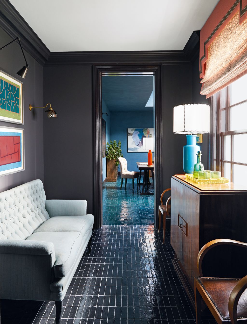 Nicola used floor tiles throughout this house adding a glossy dramatic touch in multiple spaces. Here in the hall...