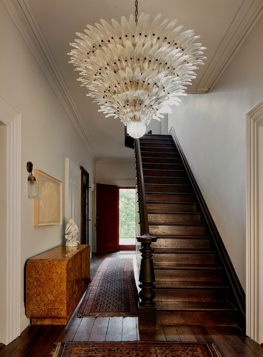 The entryway of the home has a 1970s roundededgenbspPace credenza hugging the hallway. A vintage Persian carpet...