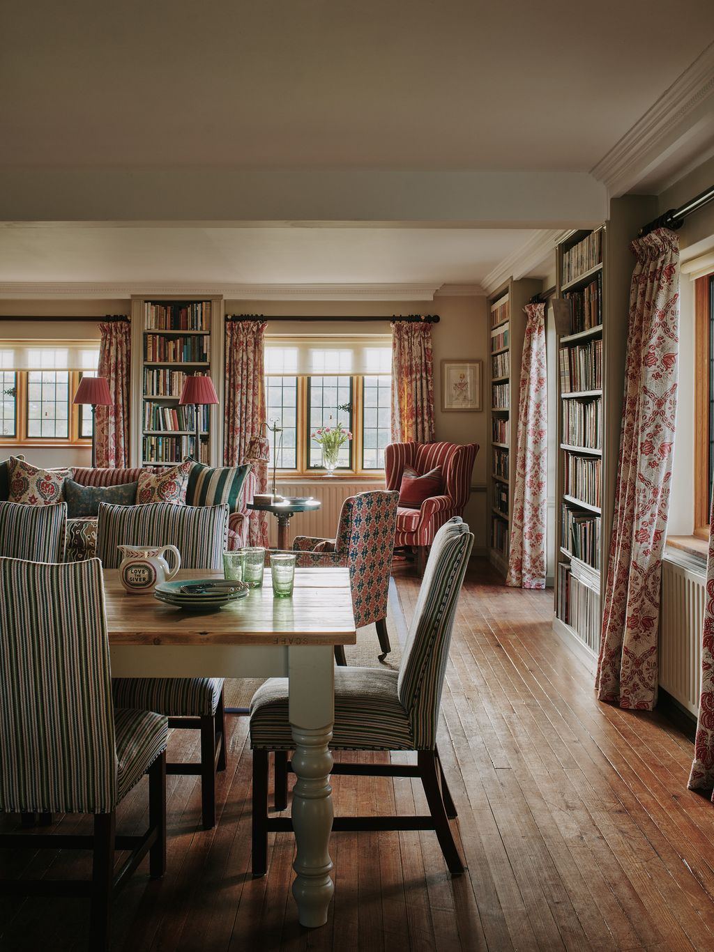 Bridging the gap between the kitchen and seating area is a The Farmhouse Table Company dining table paired with chair...