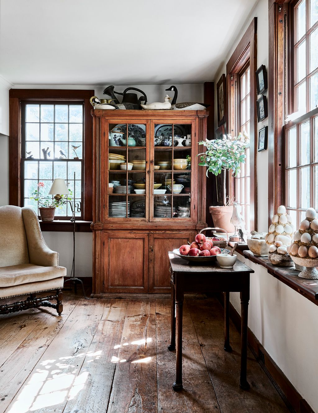 An American cupboard in kitchen houses yellowware bowls and Portuguese polychrome faience dishes.
