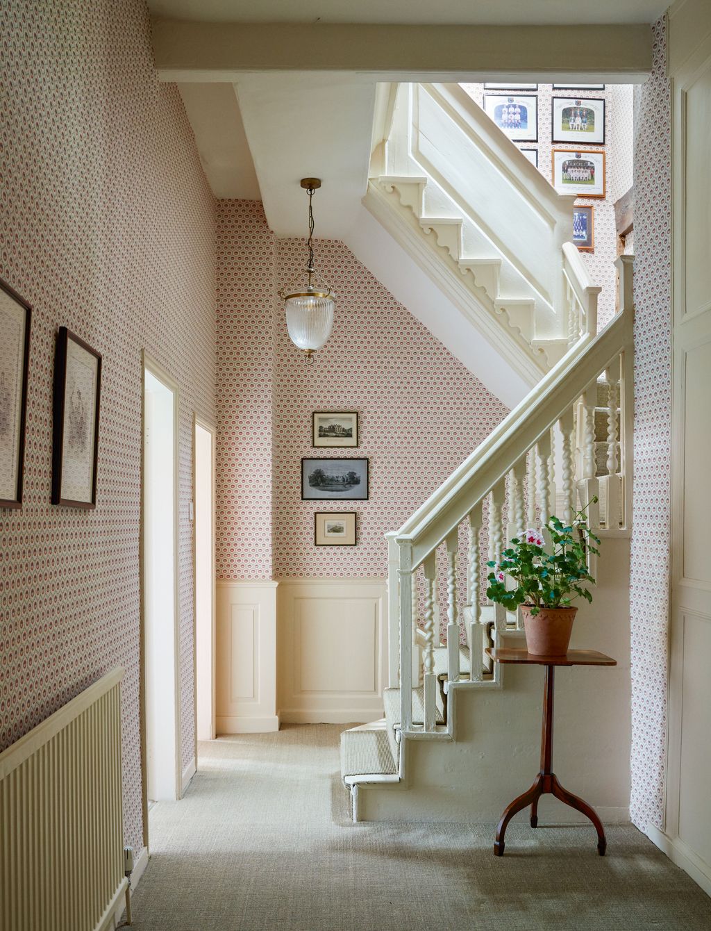 ‘Sunburst wallpaper in terracotta from Robert Kime brightens the upstairs corridor and stairwell in this handsome Queen...