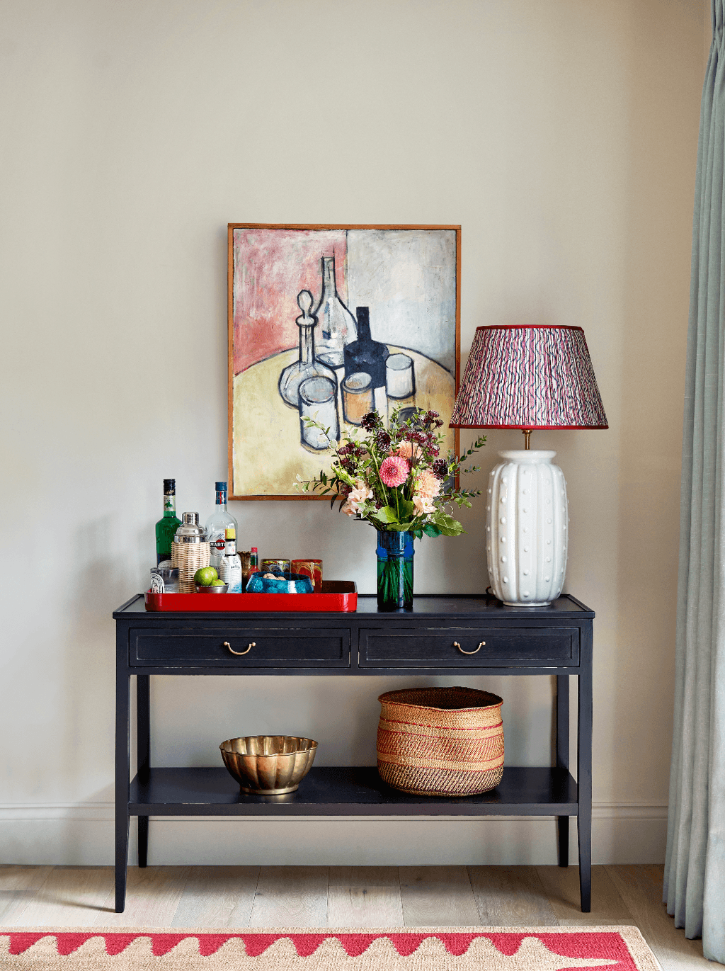 The console in the sitting room is from Chelsea Textiles. The artwork that hangs above the console is a vintage...