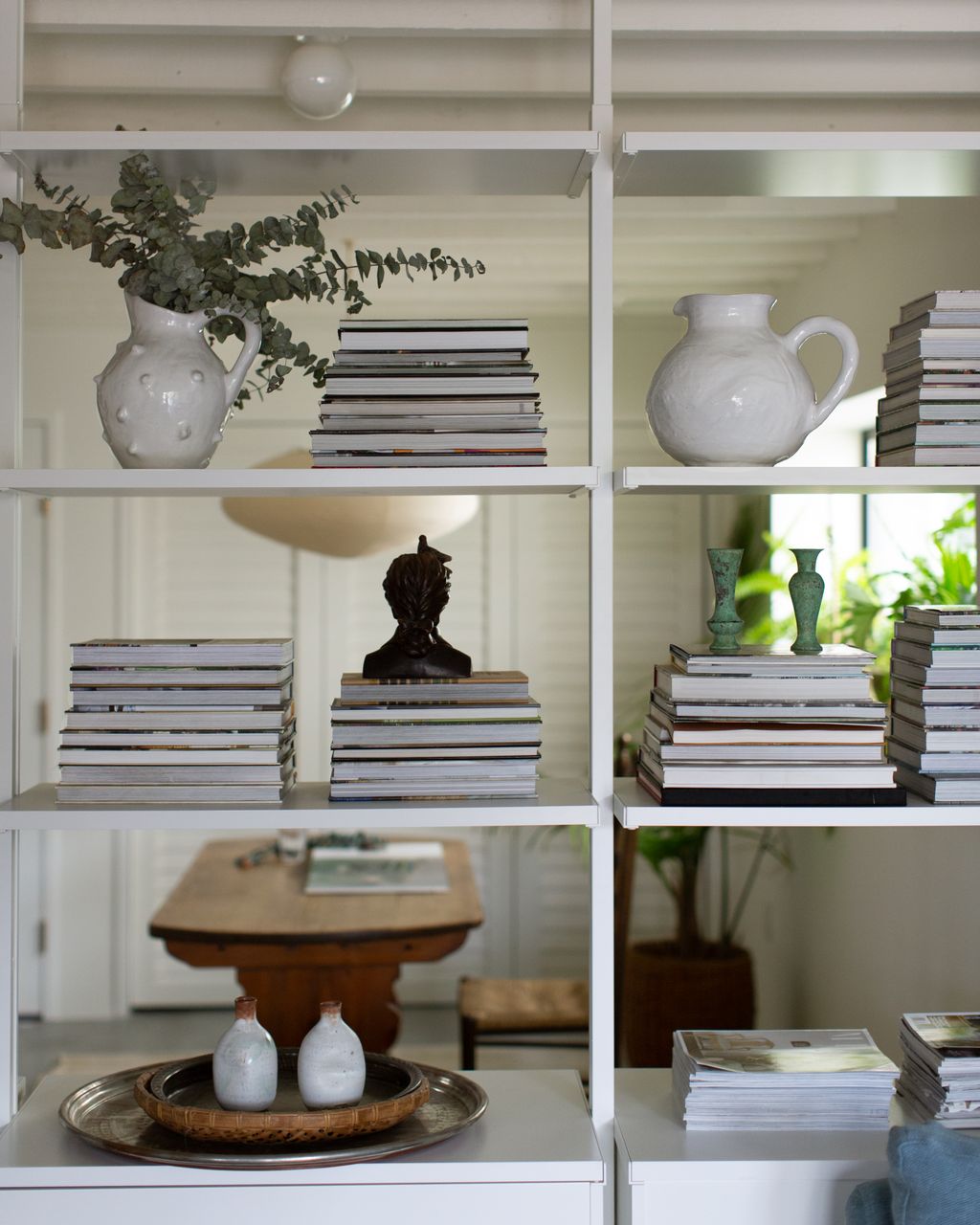 An open bookshelf bisects the room creating an alcove for an office.