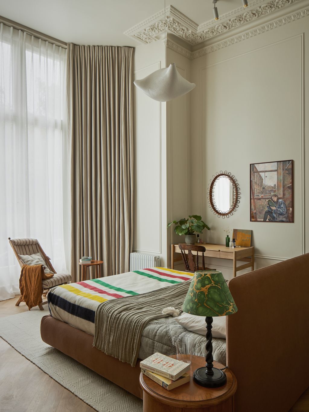 Curtains which hang from the highest point on the all accentuate the tall ceilings in the bedroom.