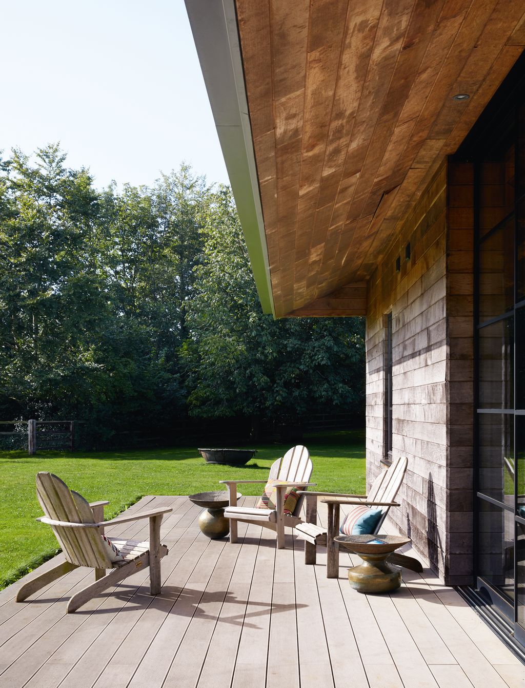 Teak Adirondack chairs from Gloster are positioned to make the most of the sun and the views of the countryside on the...