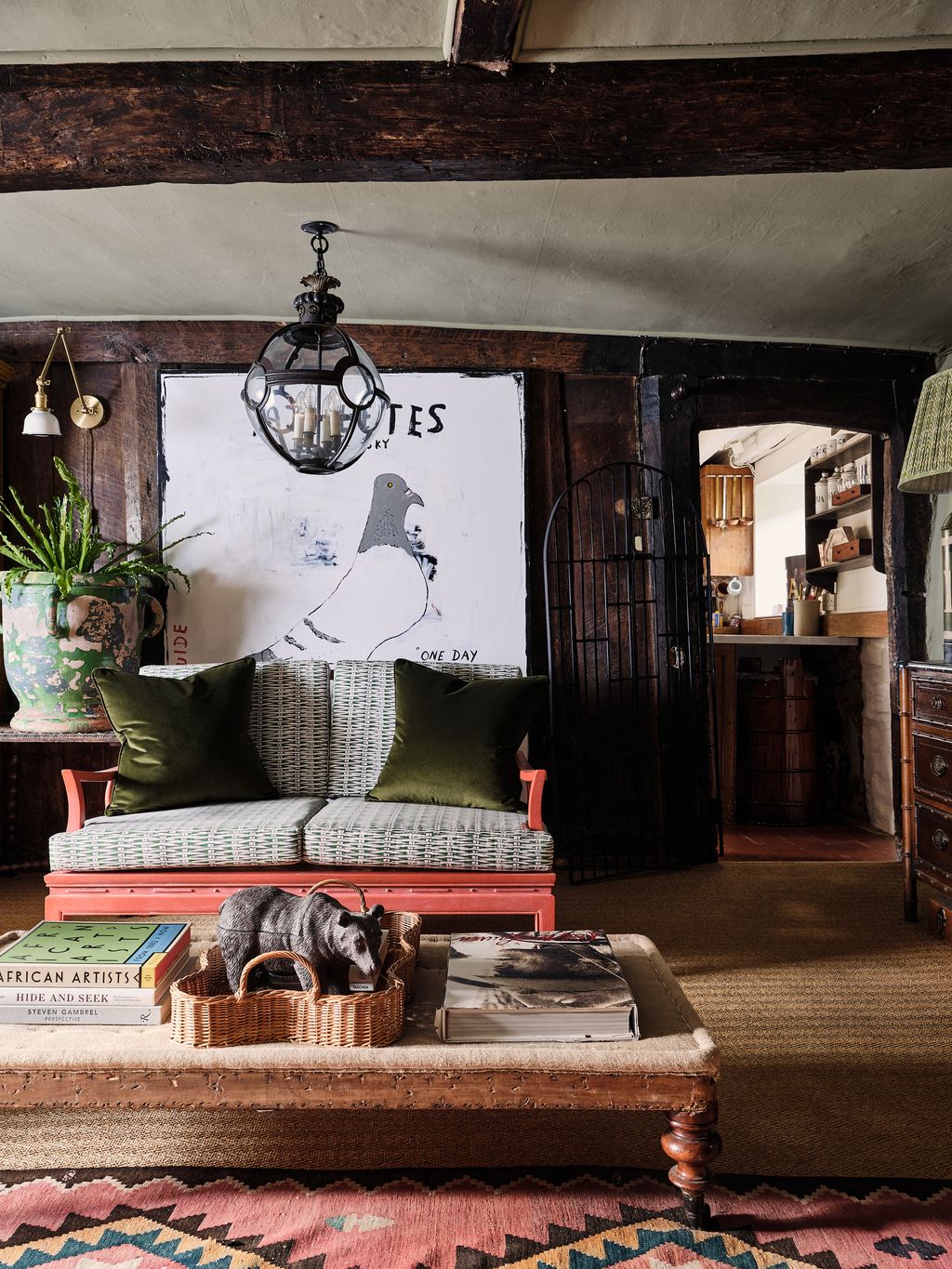 The sitting room has a door into the kitchen beyond. ‘Athletes of the Sky an original artwork by Richie Culver hangs...