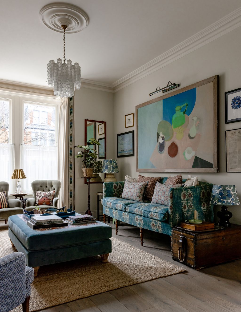 The sofa is upholstered in ‘Tribal by Lewis Wood above which a painting by an unknown artist hangs which they bought...