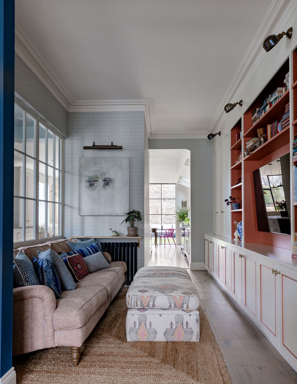 The walls in the TV room are covered in ‘Wattle Blue wallpaper by Robert Kime.