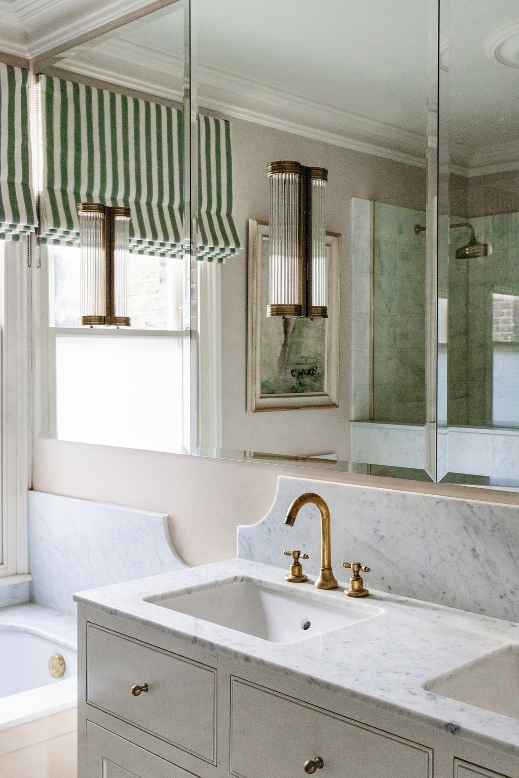 A green stripe blind adds a burst of colour against the neutral walls and light marble.
