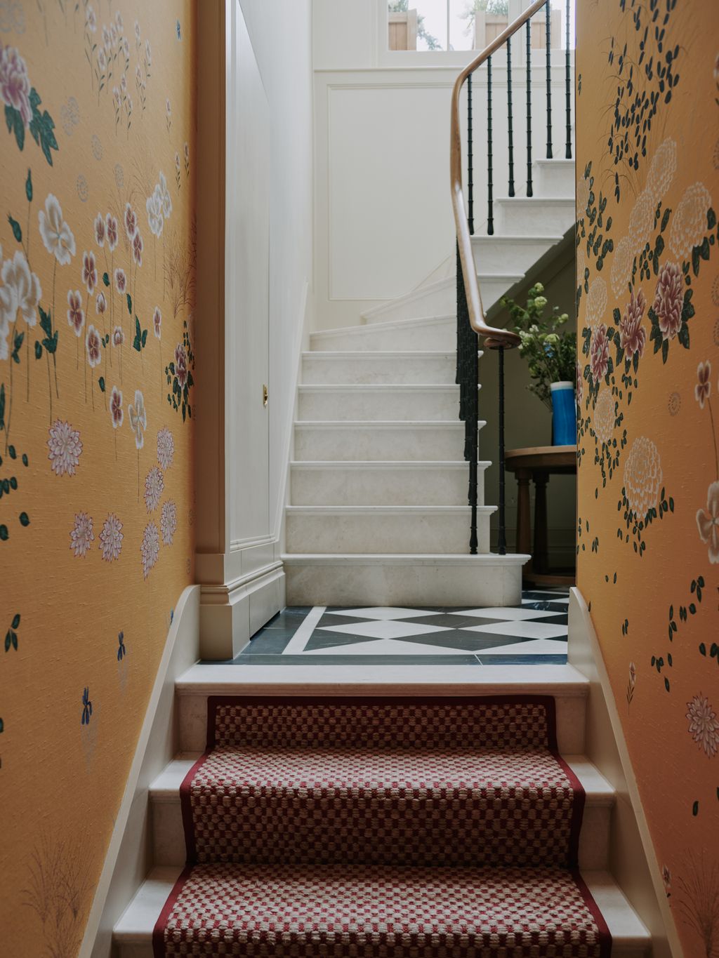 The staircase leading to the entrance hall in this Mayfair apartment by Salvesen Graham is covered in a pretty saffron...