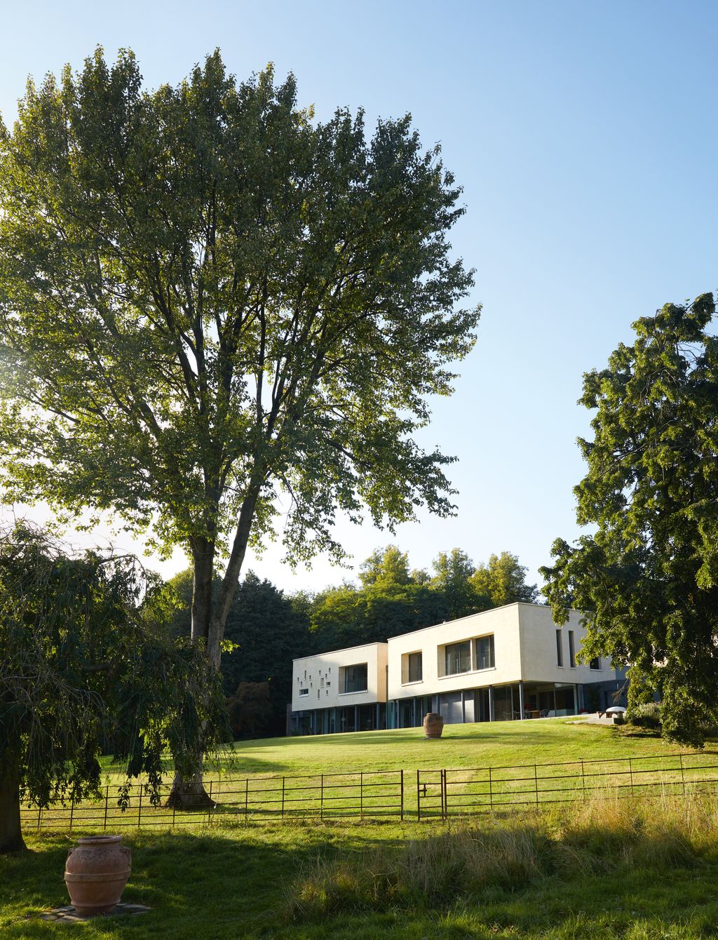 The limestoneclad second storey appears to float as the steel columns and glass below blend with the setting.