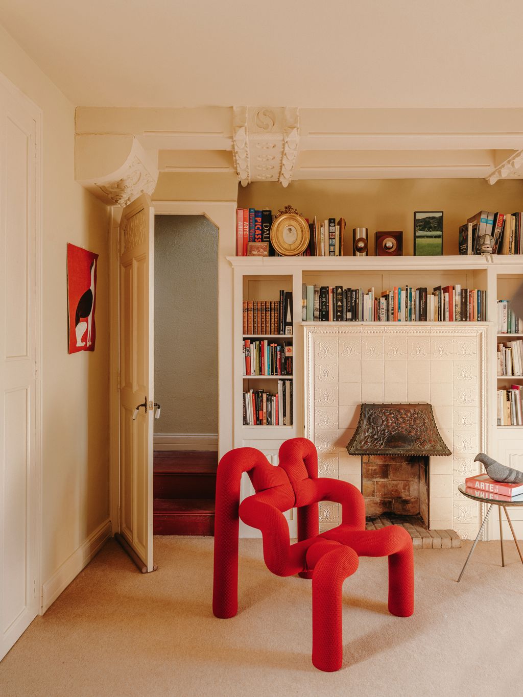 The original fireplace and intricate ceiling mouldings provide an elegant backdrop for the distinctive steel foam and...