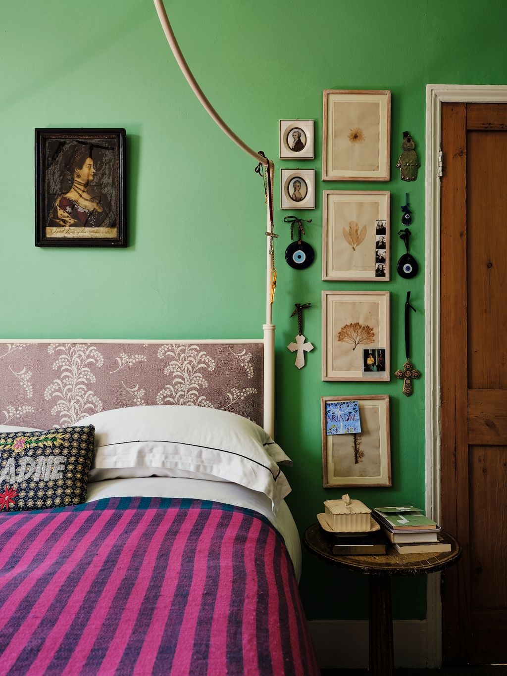 Above the bed hangs an 18th century reverse glass mezzotint portrait of Queen Charlotte next to a collection of 19th...