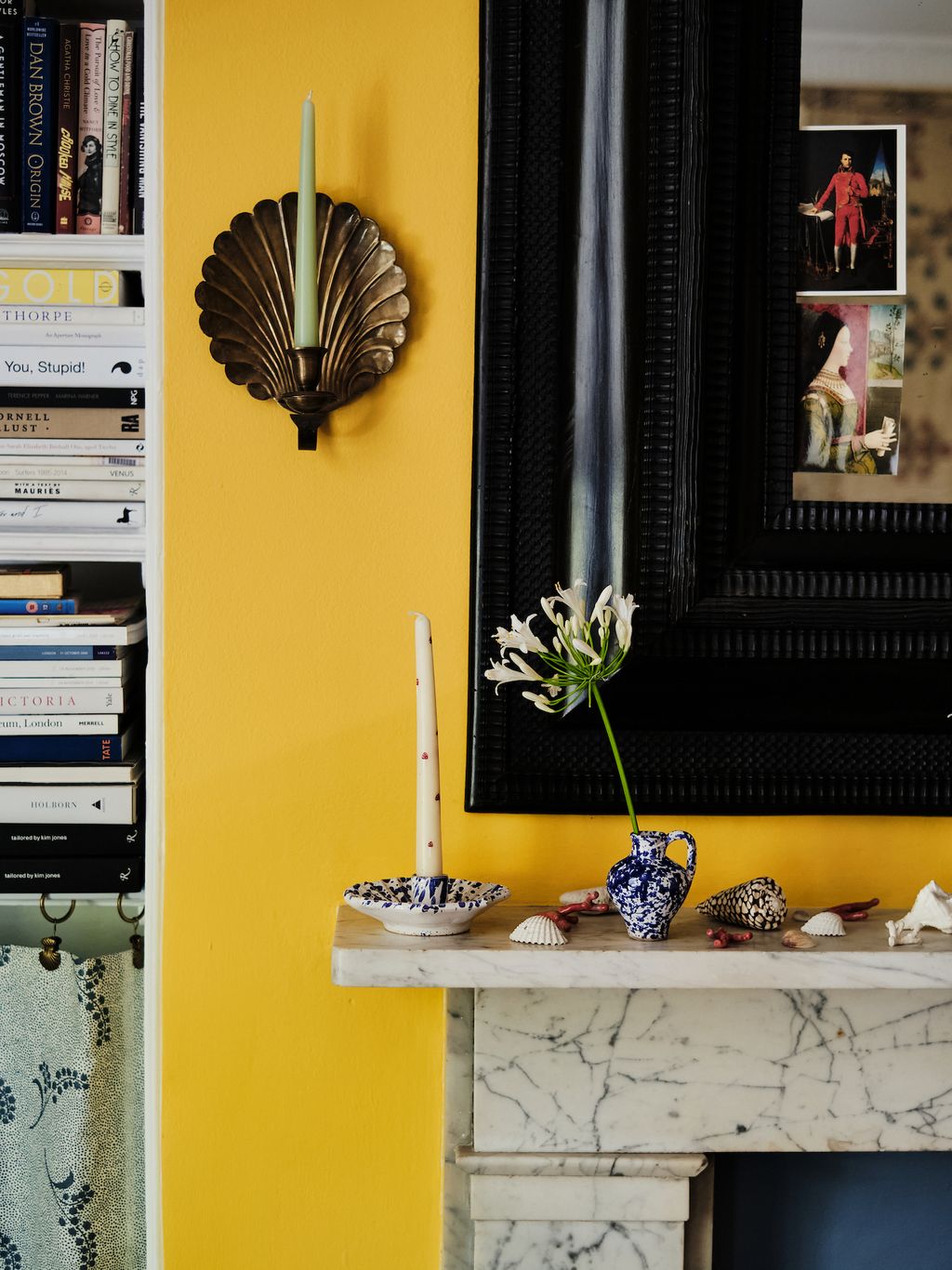 The mantlepiece is covered if a collection of shells picked up on their travels. The candle holder and bud vase are both...