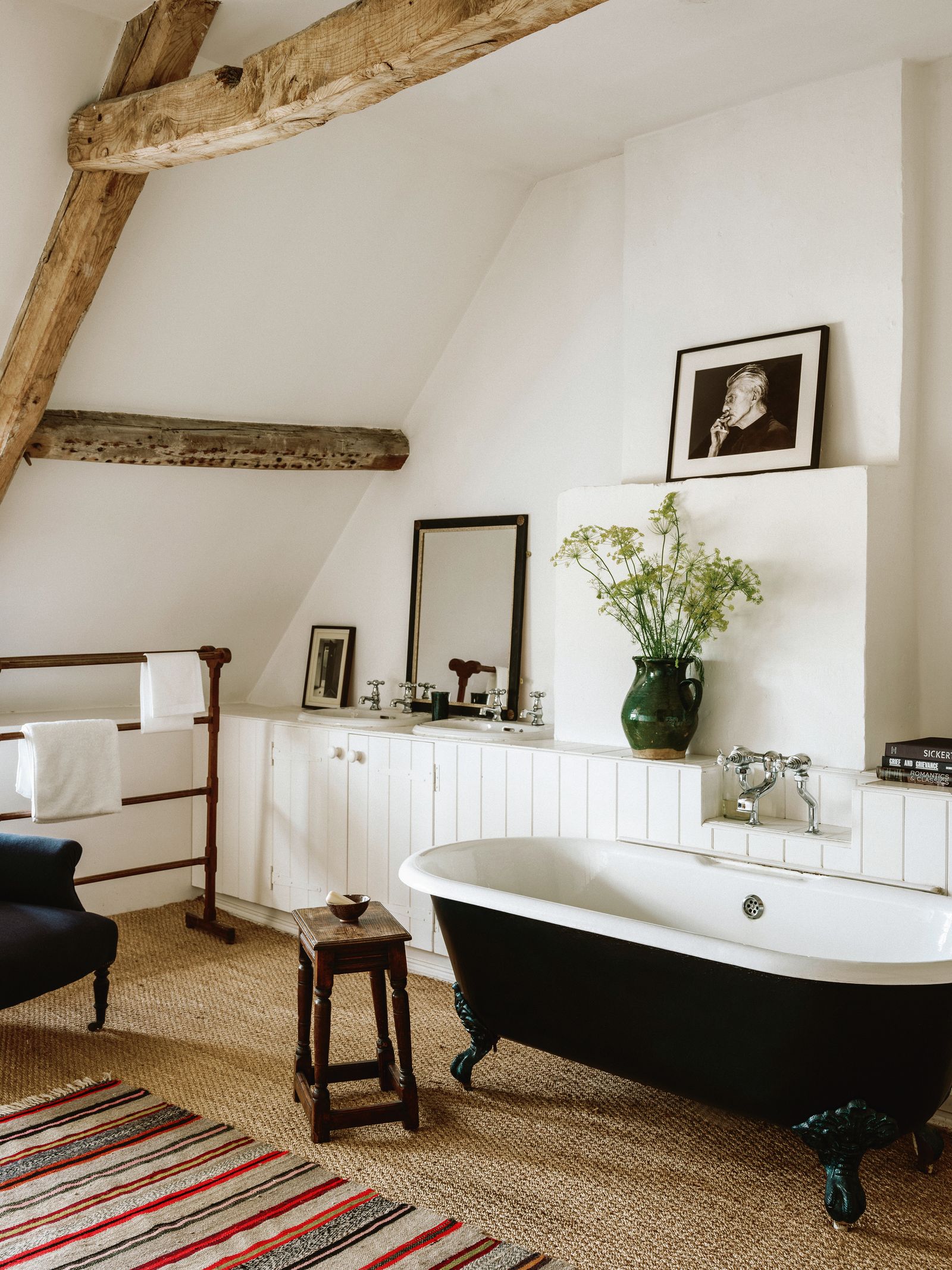 Built in joinery covered in tongue and groove panelling conceals the bath and sink plumbing in this Gloucestershire...