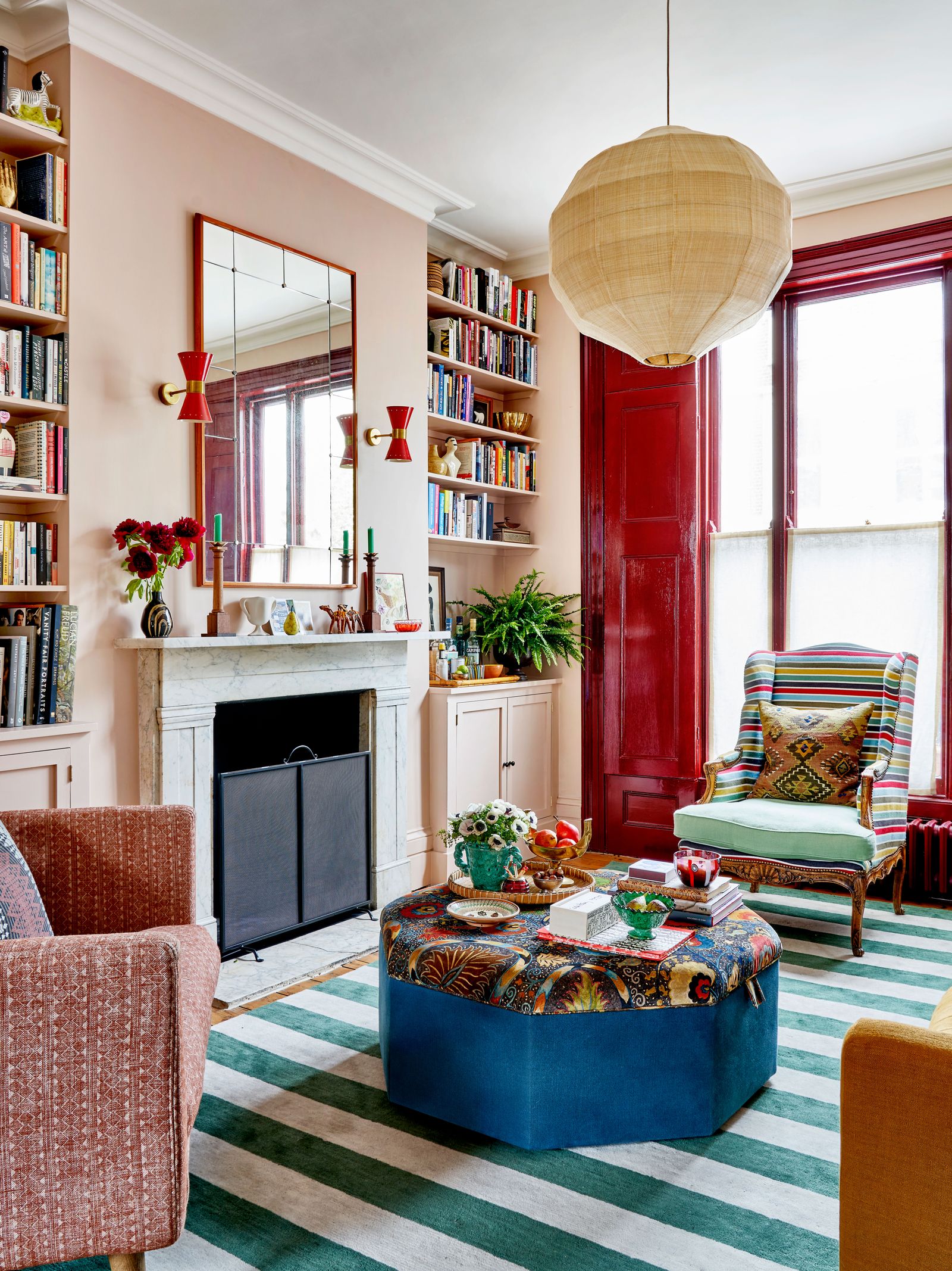 A wingback chair in the sitting room of a house by Lonika Chande who reupholstered it in a Soane stripe with a seat...