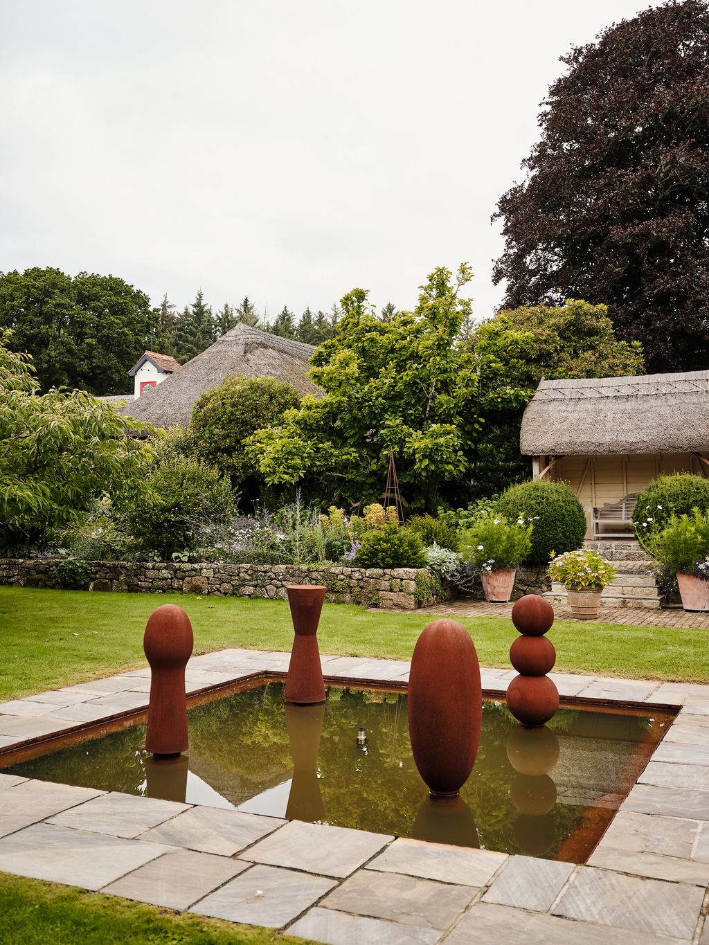 On what was a grass tennis court Hugo and Blanche have added a pond and fountain with Antony Gormley bollard sculptures.