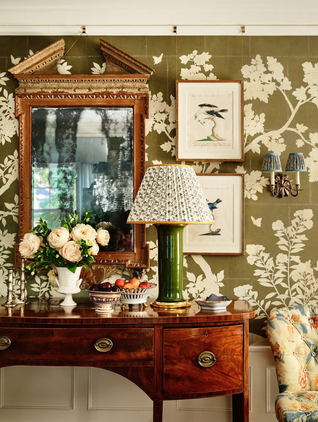 A Gracie wall covering provides a backdrop for an antique mirror in the dining room.