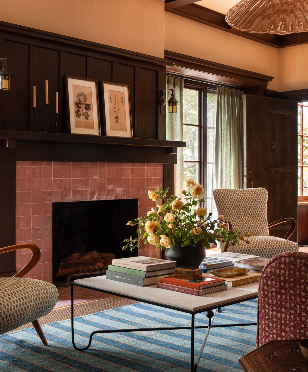 Pink zellige tiles around the fireplace are a playful counterpoint to the wood panelling.