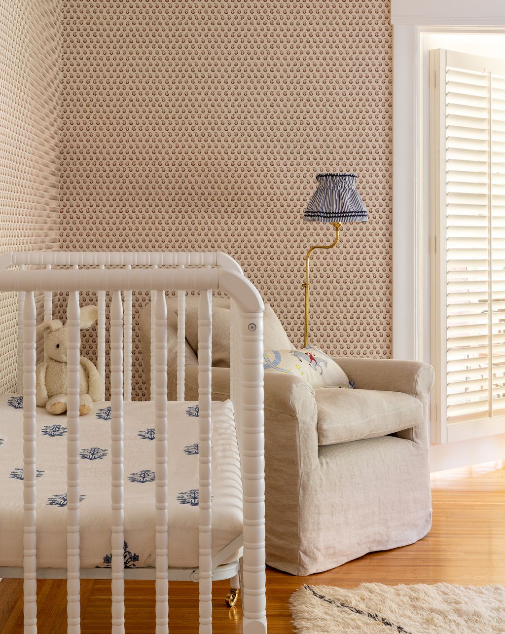 A delicate floral paper on the landing leads to a sweet nursery.