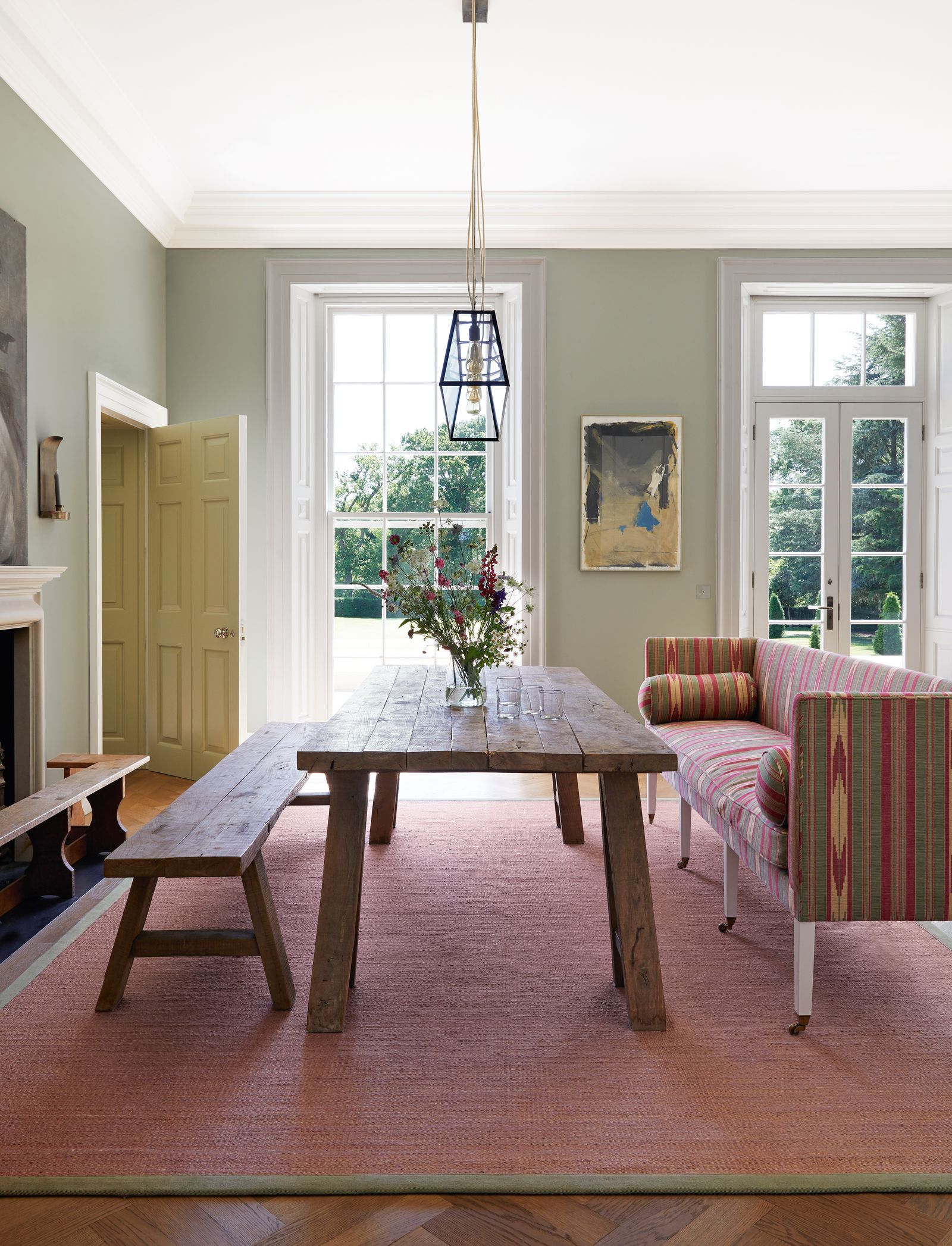 A jute rug in a custom colourway from Stark demarcates a dining area where the rustic wooden table and bench are...